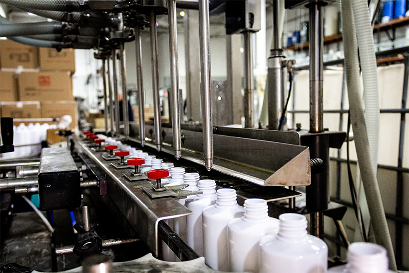 ResistAll bottles moving down a conveyor belt to be filled with appearance care protection solution