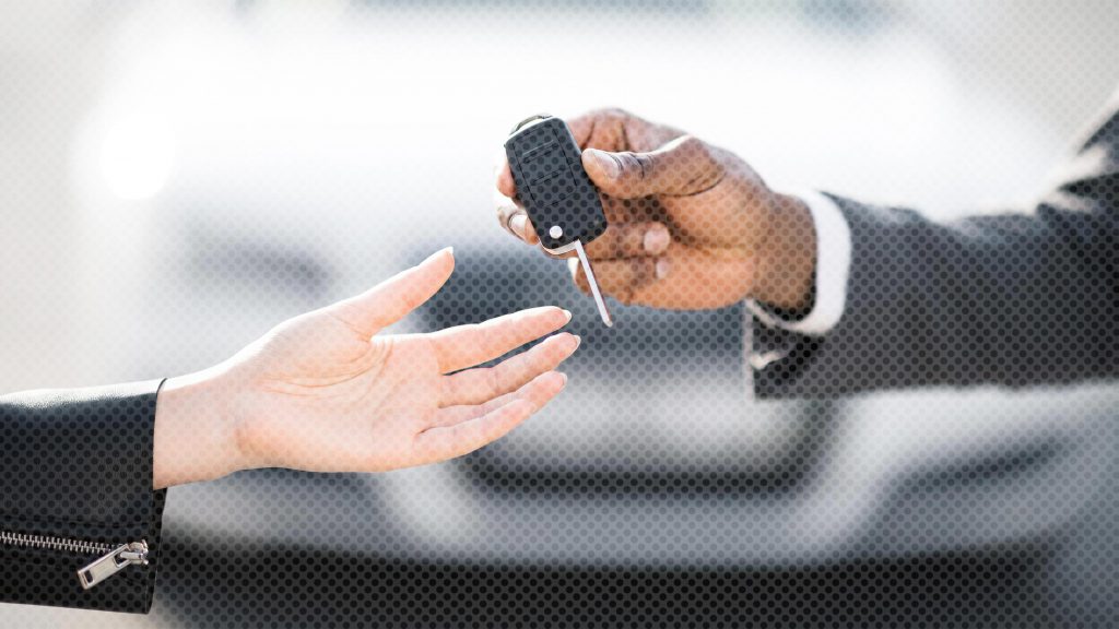 Car salesman handing a customer the key to a newly purchased vehicle with ResistAll protection