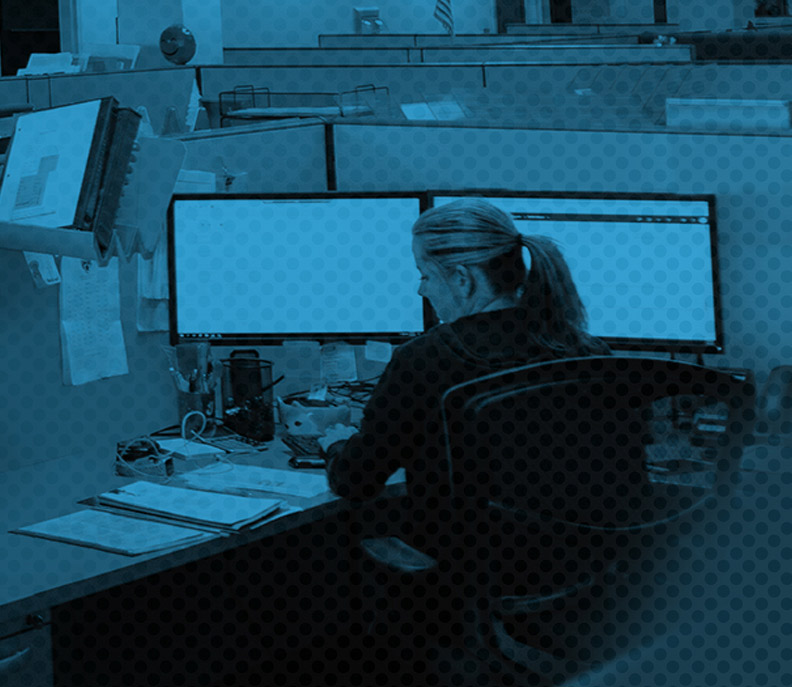 CalTex employee at a desk, hard at work looking at two monitors and displaying excellence 
